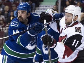 Canucks defenceman Erik Gudbranson, left, tries to clear Arizona Coyotes centre Martin Hanzal from in front of the Canucks' net during NHL action at Vancouver in November last year.