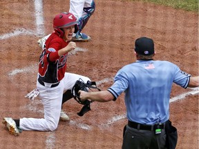 Canada's Matteo Manzi, left, celebrates after scoring the second of two runs on a single by Robert Orr off Italy starting pitcher Riccardo Nepoti during the second inning of an international pool play baseball game against Italy at the Little League World Series tournament in South Williamsport, Pa.,