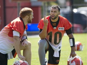 B.C. Lions quarterback Jonathon Jennings , right, talks with Travis Lulay at the B.C. Lions Training facility in Surrey. Jennings took first-team reps at practice Wednesday for the first time since injuring his shoulder July 15 in Hamilton.