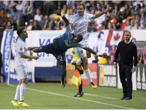 Vancouver Whitecaps forward Bernie Ibini-Isei fights for control of the ball with Seattle Sounders' defender Will Bruin, right, during the second half of Major League Soccer action in Vancouver on Wednesday night. The teams played to a 1-1 tie.