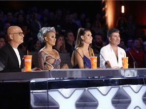 In this Tuesday, Aug. 22, 2017 photo provided by NBC, judges Howie Mandel, Mel B, Heidi Klum and Simon Cowell participate in a live broadcast of "America's Got Talent" in Los Angeles. Mel B threw a cup of water on Cowell and walked off the stage after Cowell made a joke about her wedding night during the show.