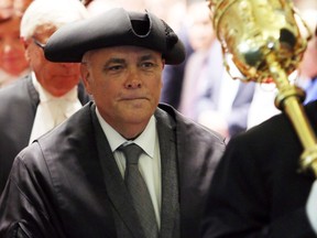 Speaker Darryl Plecas is escorted by the sergeant-at-arms at the legislature in Victoria on Friday, shortly after taking on the post.