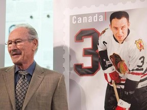 Pierre Pilote smiles beside his stamp during the unveiling of the NHL stamp series featuring the Original Six Defencemen at the Hockey Hall of Fame in Toronto on Thursday, Oct. 2, 2014. Former Blackhawks defenceman Pilote, who won a Stanley Cup with Chicago in 1961, has died. He was 85. The Blackhawks said in a statement Sunday that Pilote had died Saturday night. THE CANADIAN PRESS/Hannah Yoon