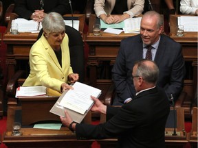 B.C. Finance Minister Carole James passes a letter from Lt.-Gov. Judith Guichon before delivering the budget as Premier John Horgan looks on from the legislative assembly at Legislature in Victoria, B.C., on Monday, September 11, 2017. THE CANADIAN PRESS/Chad Hipolito ORG XMIT: CAH501