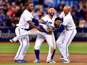 Toronto Blue Jays shortstop Richard Urena (7) is mobbed by teammates Teoscar Hernandez, left to right, Kevin Pillar and Ryan Goins after hitting a game winning RBI single against the Baltimore Orioles during ninth inning American league baseball action in Toronto on Tuesday, Sept. 12, 2017. THE CANADIAN PRESS/Frank Gunn