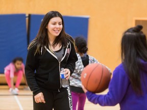 Verdann, youth co-ordinator for the Red Fox Healthy Living Society, an after-school program funded by the United Way, playing basketball with children in the program.