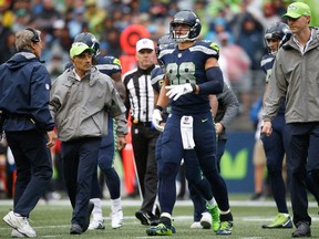 Tight end Jimmy Graham of the Seattle Seahawks walks off the field with trainers after injuring his ankle during the second quarter of the game at CenturyLink Field last Sunday. He's expected to start this week despite the setback.