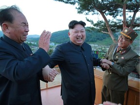 A photo taken on May 14, 2017 and released from North Korea's official Korean Central News Agency on May 15 shows North Korean leader Kim Jong-Un (centre) reacting during a test launch of a ground-to-ground, medium long-range strategic ballistic rocket Hwasong-12 at an undisclosed location.