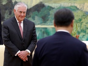 US Secretary of State Rex Tillerson (L) looks at Chinese President Xi Jinping walking to his seat during a meeting at the Great Hall of the People in Beijing on September 30, 2017.