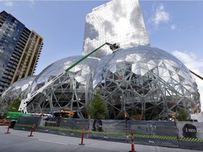 FILE - In this April 27, 2017 file photo, construction continues on three large, glass-covered domes as part of an expansion of the Amazon.com campus in downtown Seattle. Amazon said Thursday, Sept. 7, that it will spend more than $5 billion to build another headquarters in North America to house as many as 50,000 employees. It plans to stay in its sprawling Seattle headquarters and the new space will be "a full equal" of its current home, said founder and CEO Jeff Bezos.