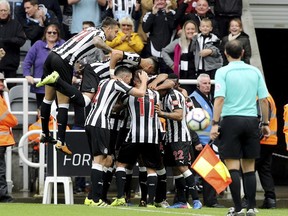 Newcastle United's Jamaal Lascelles, obscured, celebrates with team-mates after scoring his team's second goal against Stoke City during their English Premier League soccer match at St James' Park in Newcastle last Saturday.