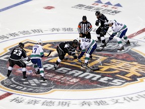 Players of the Los Angeles Kings, and the Vancouver Canucks fight for the puck during the NHL China preseason hockey game at Mercedes-Benz Arena in Shanghai, China, Thursday, Sept. 21 , 2017