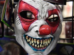 A clown mask hangs in a Halloween store.