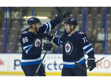Winnipeg Jets Antoine Crete-Belzile (72) is congratulated by teammate Mathieu Sevigny after scoring against the Vancouver Canucks.