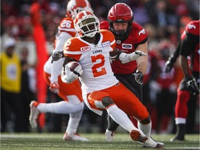 B.C. Lions' Chris Rainey, left, tries to evade Calgary Stampeders' Charlie Power during a September 2017 game in Calgary.