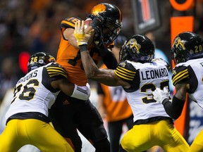 B.C. Lions' Bryan Burnham, second left, is stopped short of the end zone by Hamilton Tiger-Cats' Cariel Brooks, from left, Richard Leonard and Emanuel Davis during the first half of Friday's game at B.C. Place.