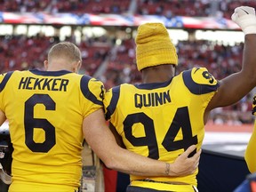 Los Angeles Rams punter Johnny Hekker (6) puts his arm around defensive end Robert Quinn (94), who raises his fist during the national anthem before an NFL football game between the San Francisco 49ers and the Rams in Santa Clara, Calif., Thursday, Sept. 21, 2017. (AP Photo/Ben Margot)