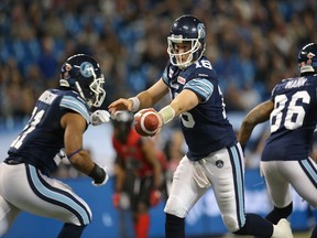 Mitchell Gale of the Toronto Argonauts hands the ball off to Anthony Woodson during CFL game action against the Ottawa Redblacks on Nov. 7, 2014 at Rogers Centre in Toronto.