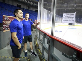 Vancouver Canucks Bo Horvat (left) and Daniel Sedin look out to the ice surface — and the bilingual sign on the glass — before the team’s practice at Mercedes-Benz Arena in Shanghai, China, on Sept. 19, 2017. The Canucks and Los Angeles Kings are in China to play two pre-season games.