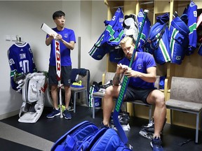 Vancouver Canucks goaltenders Zehao Sun and Anders Nilsson tape their sticks before their practice at Mercedes-Benz Arena September 19, 2017 in Shanghai, China.