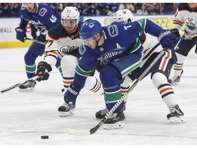 Jayson Megna of the Vancouver Canucks is chased by Edmonton Oilers' Oscar Klefbom, left, during NHL pre-season action in Edmonton.
