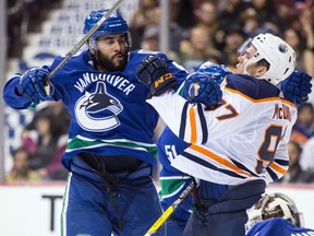 Darren Archibald check Connor McDavid during the third period of Saturday's final preseason game.