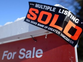 A real estate sold sign is shown outside a house in Vancouver