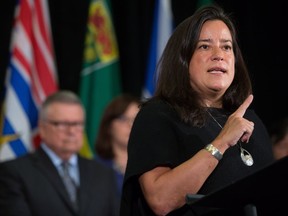 Federal Justice Minister Jody Wilson-Raybould makes a point as Minister of Public Safety and Emergency Preparedness Ralph Goodale (back left) listens at a news conference after a meeting of federal, provincial and territorial ministers responsible for justice and public safety, in Vancouver on Sept. 15, 2017.
