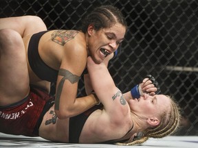 Amanda Nunes of Brazil, top, and Valentina Shevchenko of Kyrgyzstan battle during their mixed martial arts bout at UFC 215 in Edmonton on Saturday. Nunes retained her bantamweight title.