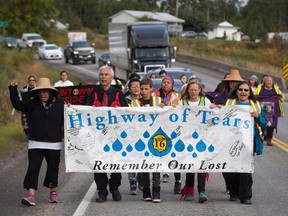 A group of family members and advocates of missing and murdered Indigenous women and girls walk along the so-called Highway of Tears, in Moricetown, B.C., on Monday.