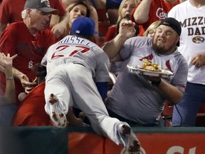 Chicago Cubs shortstop Addison Russell dives into the crowd but is unable to catch a foul ball hit by St. Louis Cardinals' Jedd Gyorko during the second inning of a baseball game Monday, Sept. 25, 2017, in St. Louis. (AP Photo/Jeff Roberson)