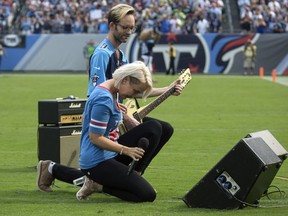 FILE - In this Sunday, Sept. 24, 2017, file photo, Meghan Linsey, a former contestant on "The Voice," kneels after singing the national anthem before the start of the Tennessee Titans and Seattle Seahawks football game at Nissan Stadium in Nashville, Tenn.