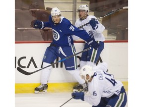 Brandon Sutter, wearing No. 20 at Canucks' training camp on Thursday, battles along the boards at Rogers Arena in Vancouver.