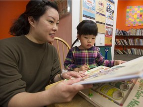 Heidi Leung reads a book with her daughter Madeline Chong at the Oakridge VPL branch in Vancouver. Madeline is enrolled in sensuous storytime, a program for children who have various troubles being in larger groups.