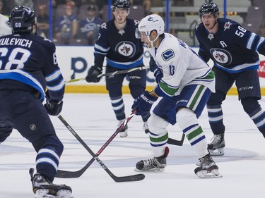 Vancouver Canucks Griffen Griffen Molino (middle) tries to get through the Winnipeg Jets defence of Jake Kulevich (68) and Jansen Harkins (58) during NHL preseason hockey.