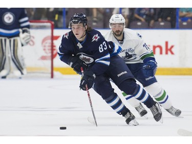 Winnipeg Jets Sami Niku skates with the puck while being chased by Vancouver Canucks Danny Moynihan.
