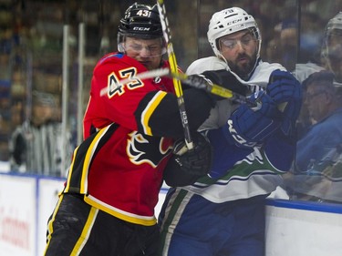 Vancouver Canucks Danny Moynihan (right) is hit by Calgary Flames Kayle Doetzel.