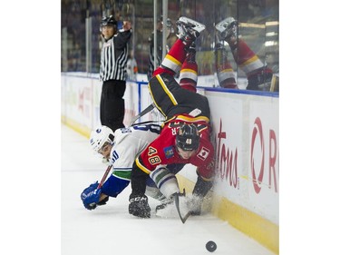 Calgary Flames Zach Fischer (right) gets upended after getting hit by Vancouver Canucks Matt Barberis.