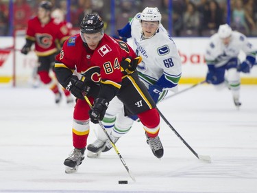 Calgary Flames Brad Morrison (left) skates with the puck while pursued by Vancouver Canucks Cole Candella