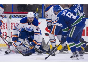 Edmonton Oilers Evan Polei (left) tries to block the shot of Vancouver Canucks Michael Carcone.