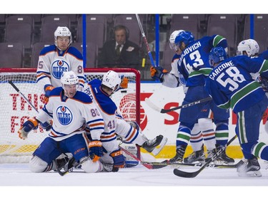 Vancouver Canucks Michael Carcone (58) fires a shot through the defence of Edmonton Oilers (from left) Liam Schioler (85), Austin Strand (80) and Evan Polei.