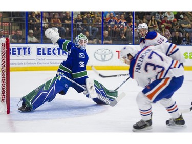 Vancouver Canucks goalie Thatcher Demko (left) slides across to face a shot from Edmonton Oilers Grayson  Pawlenchuk.