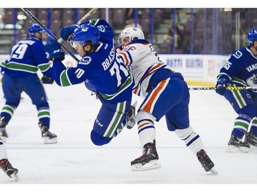Edmonton Oilers Trey Fix-Wolansky (right) hits Vancouver Canucks Matt Brassard.