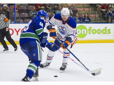 Edmonton Oilers Ziyat Paigin (right) check Vancouver Canucks Aaron Luchuk.