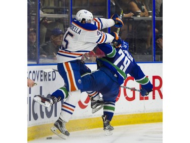 Edmonton Oilers Joe Gambardella (left) and Vancouver Canucks Danny Moynihan collide along the end boards.