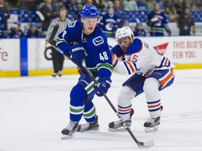 Olli Juolevi dishes the puck off while under pressure from Edmonton Oilers prospect Joe Gambardella during the recent Young Stars Classic tournament in Penticton. ‘I’m not the flashiest guy and I don’t have that many top 10 highlight goals. My thing is puck movement and that good first pass,’ says the Vancouver Canucks’ top blue-line prospect.