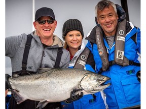 Tanya Mahe's shows off her winning catch — a 40-pound Chinook — with Evan Minigan and Paul Cheung. Mahe is the first female winner of the Fishing for Kids Tournament held annually to raise funds for the Canucks Autism Network.