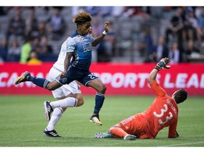 Whitecap Yordy Reyna, front left, watches his shot enter the net for a goal past Minnesota United goalkeeper Bobby Shuttleworth (33).