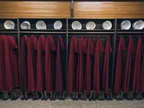 Costumes from The Handmaid's Tale are pictured hanging in a row.