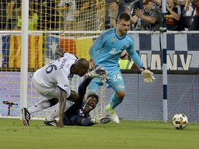 Vancouver Whitecaps midfielder Ali Ghazal tackles Sporting Kansas City forward Gerso as he at the six-yard box during the first half of the match at Children's Mercy Park.